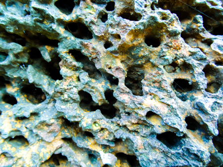 Rock with many holes and colors worn on it over timeの写真素材