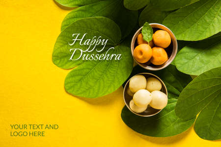 indian festival dussehra, showing golden leaf with traditional indian sweets pedha in silver bowl, Dussehra greeting cardの写真素材