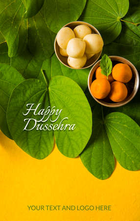 indian festival dussehra, showing golden leaf with traditional indian sweets pedha in silver bowl, Dussehra greeting cardの写真素材