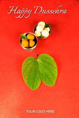 indian festival dussehra, showing golden leaf with traditional indian sweets pedha in silver bowl, Dussehra greeting cardの写真素材