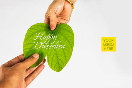 indian festival dussehra, showing golden leaf with traditional indian sweets pedha in silver bowl, Dussehra greeting cardの写真素材