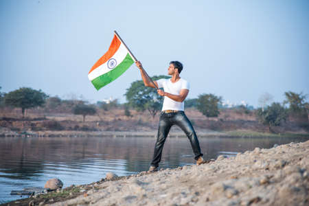 indian young man holding and waving indian flag, conceptual image for republic day or independence day, handsome man holding flag, man holding indian flag, indian flag wavingの写真素材