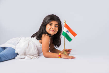 indian flag and cute little indian girl, 4 year indian girl with indian flag or tricolour, india flag & girl, girl holding indian flag, indian independence day, indian republic day, isolated on whiteの写真素材