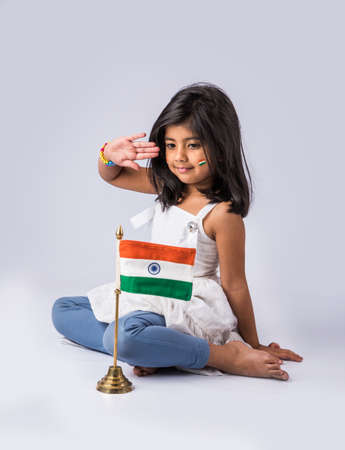 indian flag and cute little indian girl, 4 year indian girl with indian flag or tricolour, india flag & girl, girl holding indian flag, indian independence day, indian republic day, isolated on whiteの写真素材