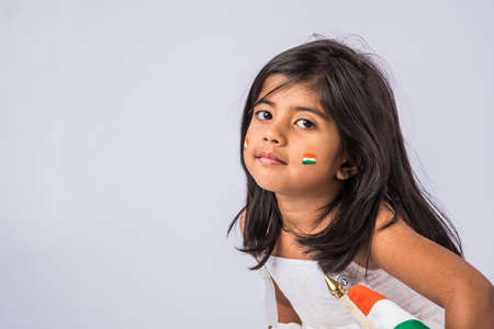 indian flag and cute little indian girl, 4 year indian girl with indian flag or tricolour, india flag & girl, girl holding indian flag, indian independence day, indian republic day, isolated on whiteの写真素材