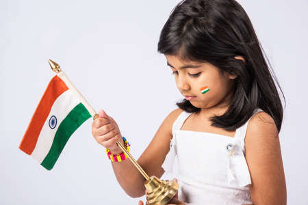 indian flag and cute little indian girl, 4 year indian girl with indian flag or tricolour, india flag & girl, girl holding indian flag, indian independence day, indian republic day, isolated on whiteの写真素材