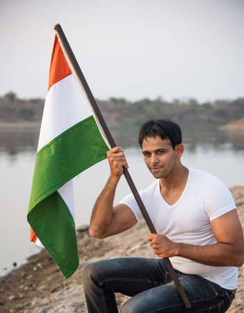 indian young man holding and waving indian flag, conceptual image for republic day or independence day, handsome man holding flag, man holding indian flag, indian flag wavingの写真素材