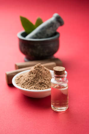 Chandan or sandalwood powder with traditional mortar, sandalwood sticks, perfume or oil and green leaves. selective focusの写真素材