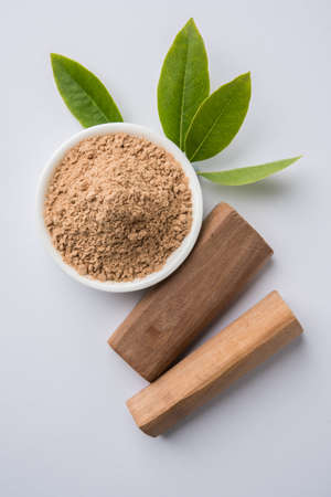 Chandan or sandalwood powder with traditional mortar, sandalwood sticks, perfume or oil and green leaves. selective focusの写真素材