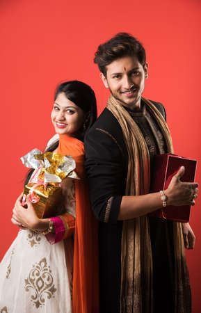 Indian Festival - Rakshabandhan or Raksha Bandhan Or Rakhi Festival also known as Narali Purnima and people, young sister tying traditional Rakhi Thread on brother's wrist or taking selfie picture or holding giftsの写真素材