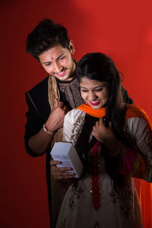 Indian Festival - Rakshabandhan or Raksha Bandhan Or Rakhi Festival also known as Narali Purnima and people, young sister tying traditional Rakhi Thread on brother's wrist or taking selfie picture or holding giftsの写真素材