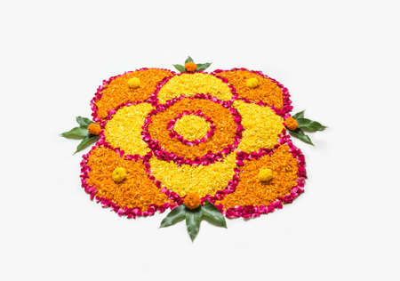 flower rangoli for Diwali or pongal made using marigold or zendu flowers and red rose petals over white background with diwali diya in the middle, selective focusの写真素材