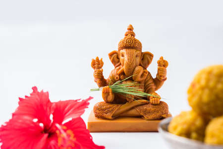 Happy Ganesh Chaturthi Greeting Card showing photograph of lord ganesha idol, pooja or puja thali, bundi laddu/modak, durva and hibiscus or jasvand flowerの写真素材