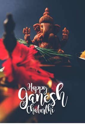 Happy Ganesh Chaturthi Greeting Card showing photograph of lord ganesha idol, pooja or puja thali, bundi laddu/modak, durva and hibiscus or jasvand flowerの写真素材