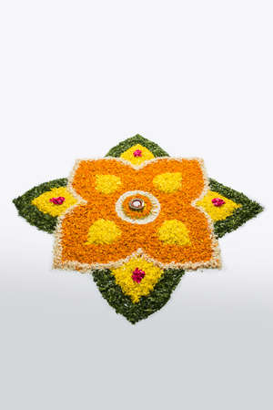 flower rangoli for Diwali or pongal or onam made using marigold or zendu flowers and red rose petals...