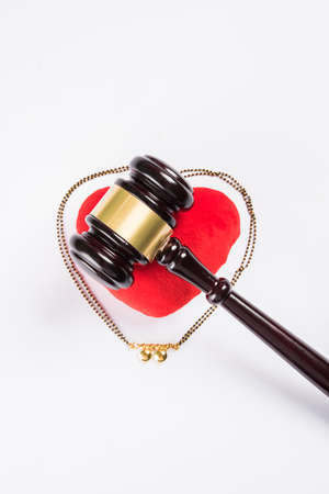 stock photo of concept of breakup or divorce in India showing Gavel, stuffed red heart, mangalsutra or necklace which is a typical Hindu traditional ornament to  wear by married women in indiaの写真素材