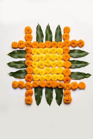 flower rangoli for Diwali or pongal or onam made using marigold or zendu flowers and red rose petals over white background with diwali diya in the middle, selective focusの写真素材