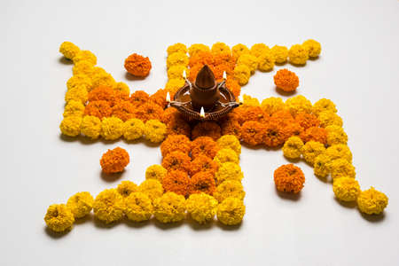 stock photo of hindu auspicious symbol called swastik made using marigold flower/zendu/genda phoolの写真素材