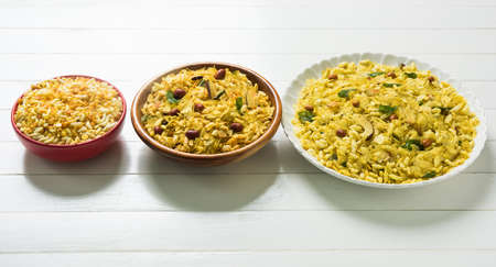 Indian traditional and popular snack poha chivda or chivada made from frying items like thin flattened rice, red chili, curry leaves, groundnuts, cashew nuts and almonds. selective focusの写真素材