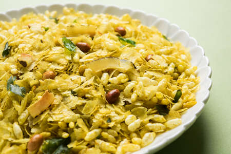 Indian traditional and popular snack poha chivda or chivada made from frying items like thin flattened rice, red chili, curry leaves, groundnuts, cashew nuts and almonds. selective focusの写真素材