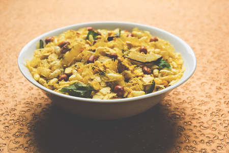 Indian traditional and popular snack poha chivda or chivada made from frying items like thin flattened rice, red chili, curry leaves, groundnuts, cashew nuts and almonds. selective focusの写真素材