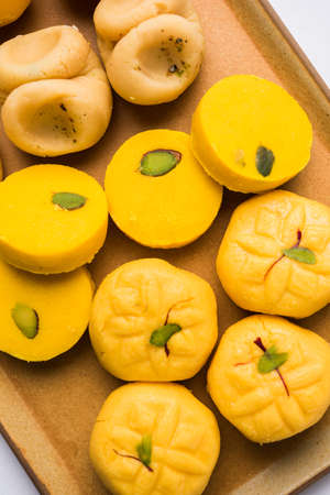 stock photo of collection of variety of sweets or orange peda or pedha or pera made up of milk, khoya, sugar , saffron etc. selective focusの写真素材