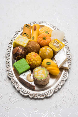 Stock photo of Indian sweets served in silver or wooden plate. variety of Peda, burfi, laddu in decorative plate, selective focusの写真素材