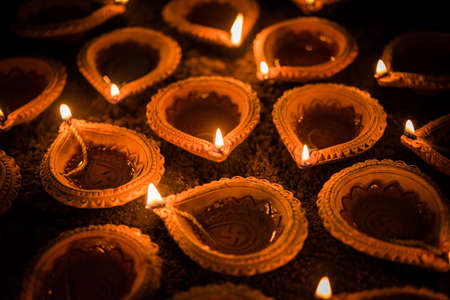 Happy Diwali - Terracotta diya or oil lamps over clay surface or ground, selective focusの写真素材