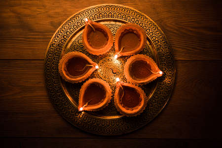 Diya in Thali - Brass Plate or thali full of Terracotta diya or oil lamps ready for decorating or illuminating house on diwali, a festival of light. selective focusの写真素材