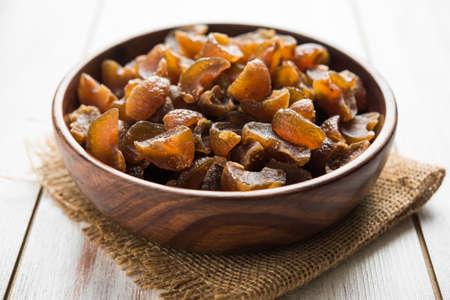 Ayurvedic Amla Candy, which is dried and salty-sweet or chatpata in taste and digestive. Served in a wooden bowl, selective focusの写真素材