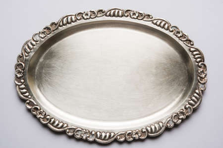 Stock photo of empty or blank silverware or oval shape plate with decorative border, isolated over white background, selective focusの写真素材