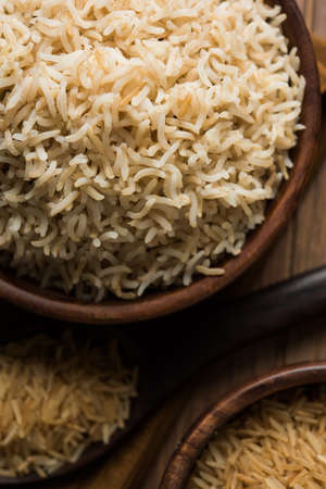 Stock photo of Indian brown wholegrain basmati cooked rice and raw rice, served in a bowl. selective...