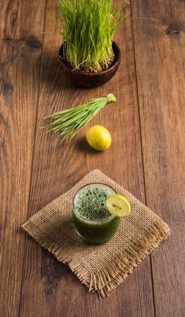 Ayurvedic or medicinal Wheat grass juice with lemon slice in glass, selective focusの写真素材