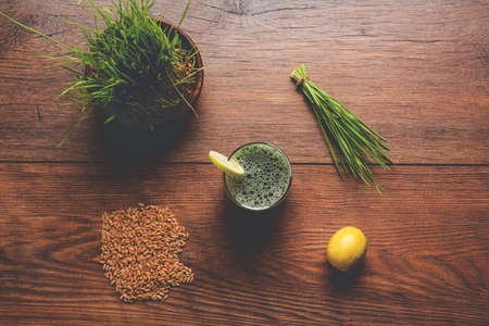 Ayurvedic or medicinal Wheat grass juice with lemon slice in glass, selective focusの写真素材