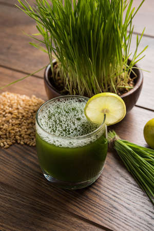 Ayurvedic or medicinal Wheat grass juice with lemon slice in glass, selective focusの写真素材