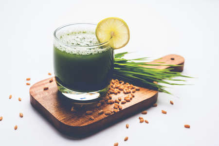 Ayurvedic or medicinal Wheat grass juice with lemon slice in glass, selective focusの写真素材