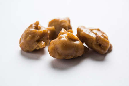 Asafoetida cake and powder or Hing or Heeng which is an important ingredient in Indian food recipes with big wooden spoon and mortar, selective focusの写真素材