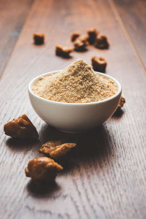 Asafoetida cake and powder or Hing or Heeng which is an important ingredient in Indian food recipes with big wooden spoon and mortar, selective focusの写真素材