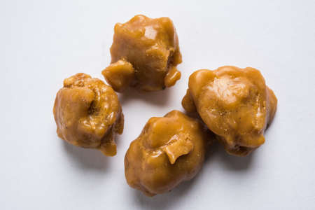 Asafoetida cake and powder or Hing or Heeng which is an important ingredient in Indian food recipes with big wooden spoon and mortar, selective focusの写真素材