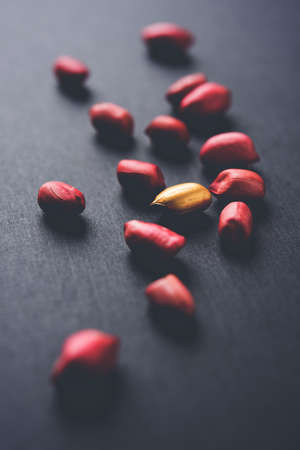 Concept of individuality, luck,value,exclusivity and better choice. Golden peanut or ground nut,...