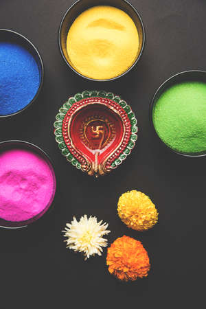 Stock Photo of happy diwali greeting card clicked using elements of Diwali festival like colourful rangoli in bowls, diwali clay lamp or diya and flowersの写真素材