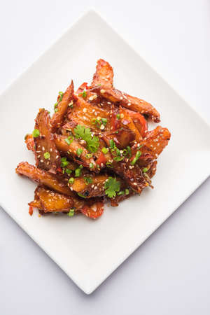honey chilli potato or Potato wedges, popular Indian-Chinese starter recipe, garnished with sesame and onion. selective focusの写真素材