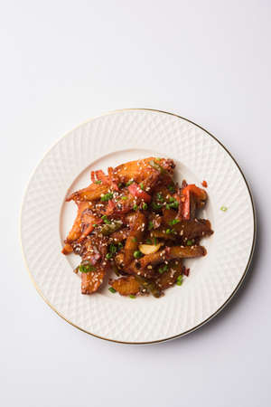 honey chilli potato or Potato wedges, popular Indian-Chinese starter recipe, garnished with sesame and onion. selective focusの写真素材