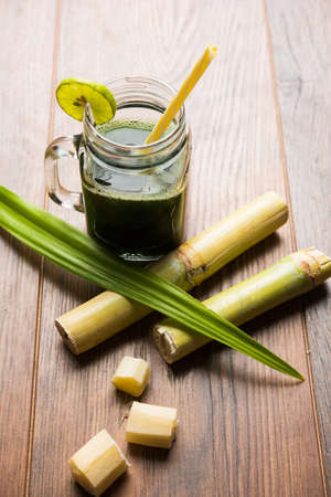 sugar cane juice or "ganne ka ras" with cut pieces cane on white backgroundの写真素材