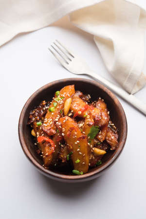 honey chilli potato or Potato wedges, popular Indian-Chinese starter recipe, garnished with sesame and onion. selective focusの写真素材