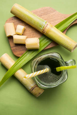 sugar cane juice or "ganne ka ras" with cut pieces cane on white backgroundの写真素材