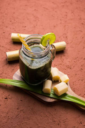 sugar cane juice or "ganne ka ras" with cut pieces cane on white backgroundの写真素材