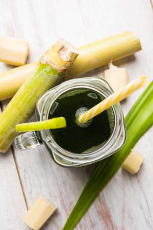 sugar cane juice or "ganne ka ras" with cut pieces cane on white backgroundの写真素材