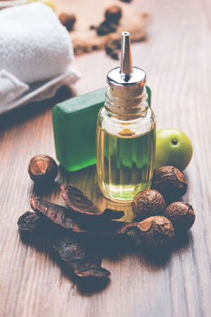 small Indian girl writing on slate with marker pen, while sitting on stool over white backgroundの写真素材