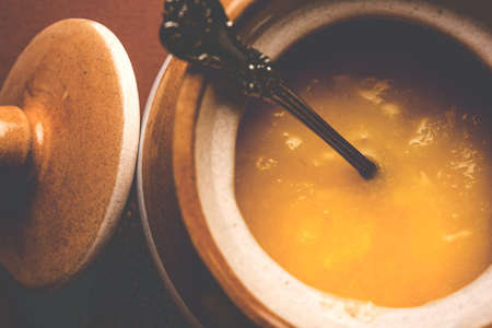 Desi Pure Ghee or clarified butter in glass or Copper container with spoon, selective focusの写真素材